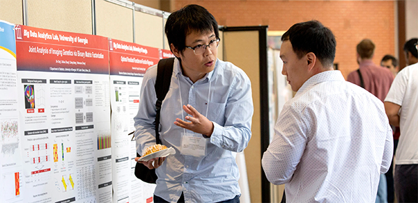 Graduate student Sun Xiaoxiao discussing research at the Informatics Symposium