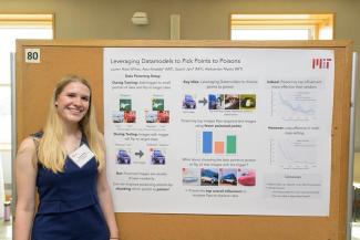 Lauren in front of her poster of work